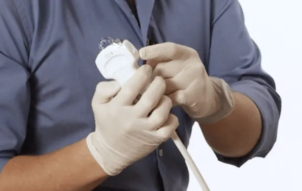 Finger pointing to the tip of an ultrasound probe.